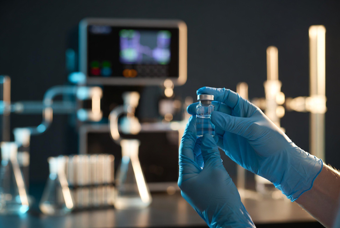 Gloved researcher inspecting a sealed peptide vial in an analytical laboratory